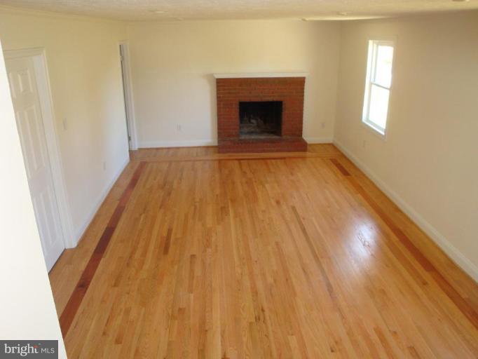 3702 Stonesboro Road Fort Washington, MD 20744 - Photo 5 of 8 a view of empty room with wooden floor and fireplace
