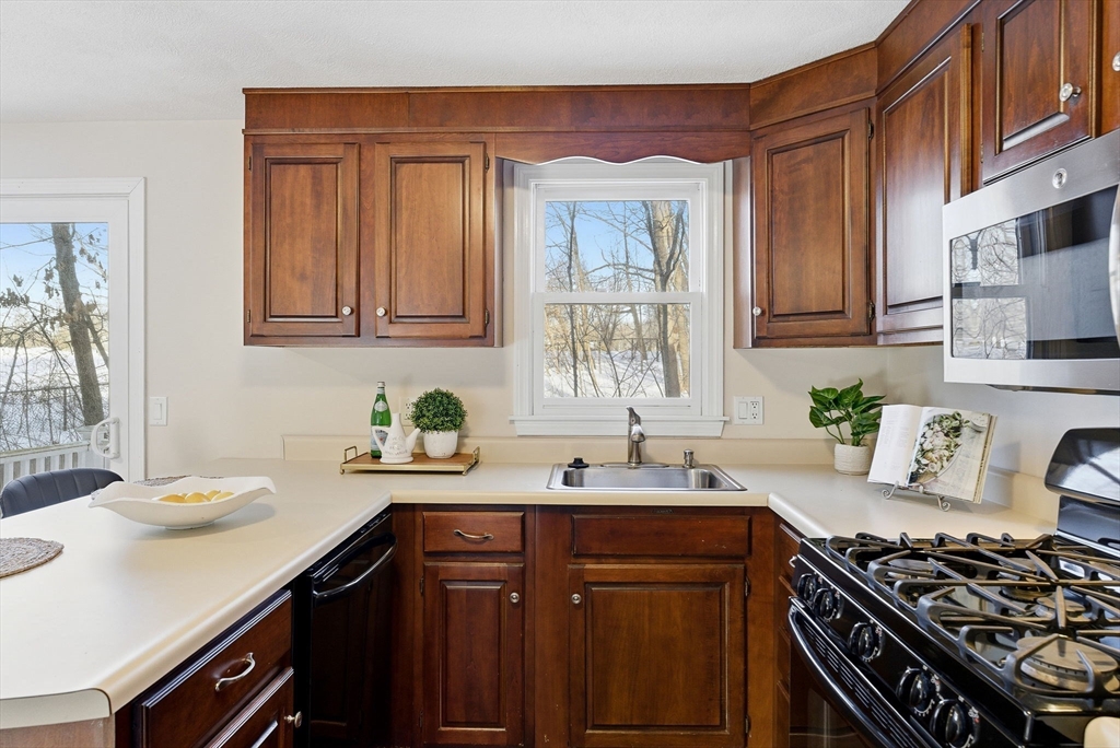 80 Swan Street, Unit 223 Lowell, MA 01852 - Photo 5 of 20 a kitchen with a sink stove top oven and cabinets