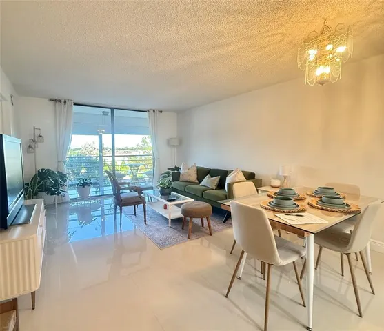 a living room with furniture a dining table and a potted plant