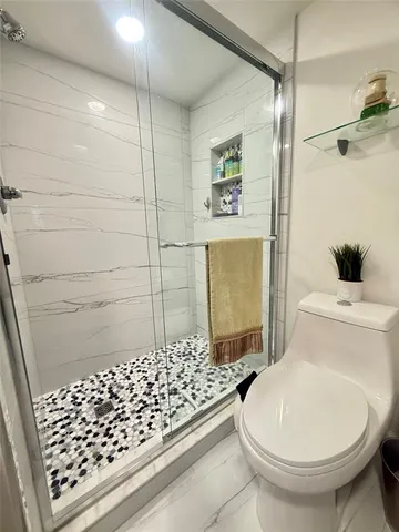 a bathroom with a toilet and a shower