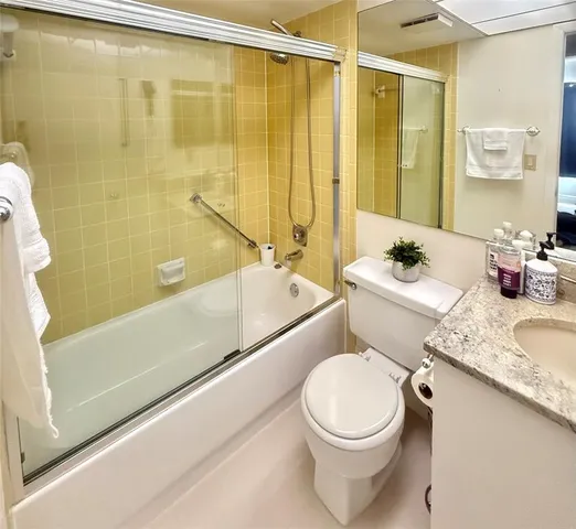 a bathroom with a double vanity sink toilet mirror and shower