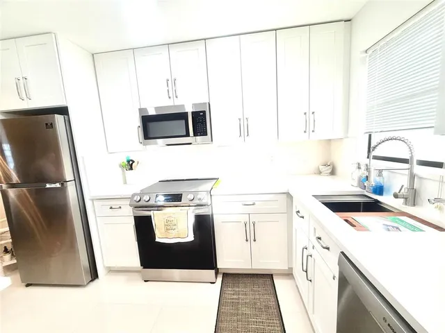 a kitchen with a stove a sink and a microwave