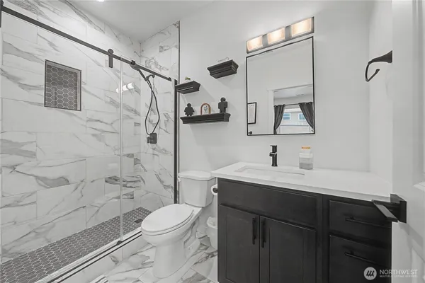 a bathroom with a sink toilet a mirror and shower