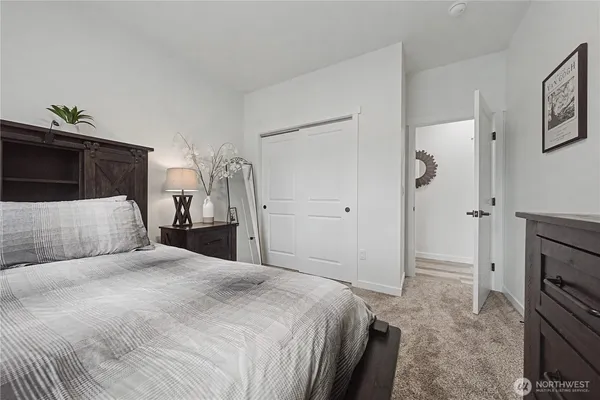 a bedroom with a bed and a refrigerator