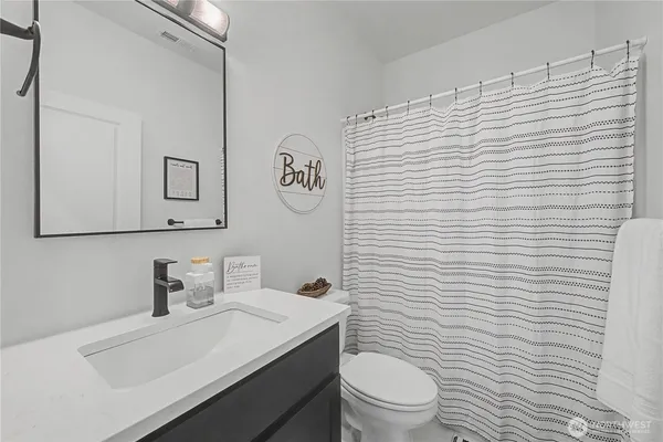 a bathroom with a toilet a sink and mirror