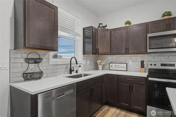 a kitchen with stainless steel appliances granite countertop a sink stove and microwave