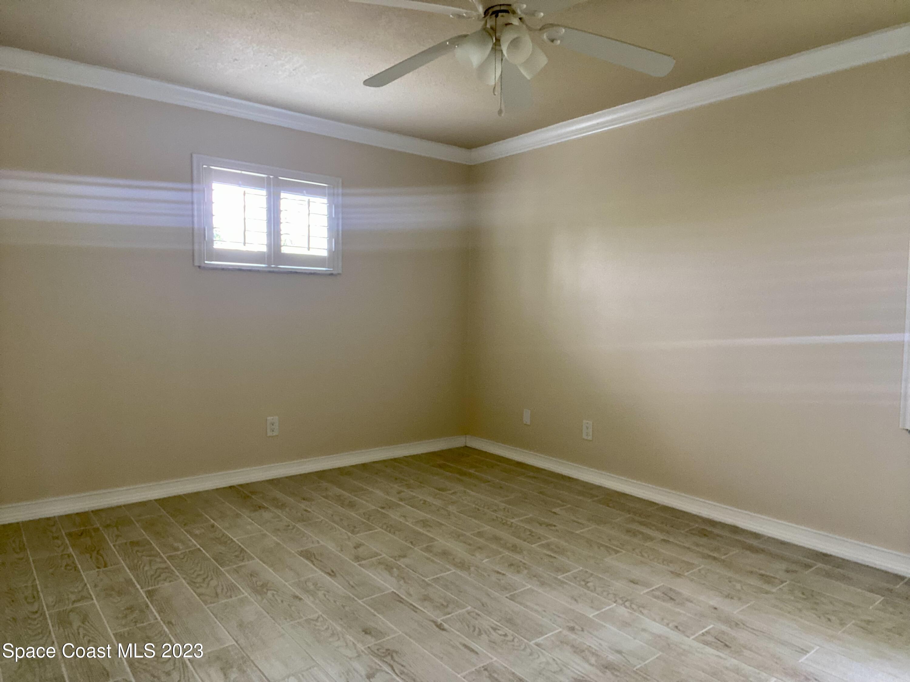 2900 Pine Branch Drive Melbourne, FL 32940 - Photo 25 of 48 an empty room with a ceiling fan and windows