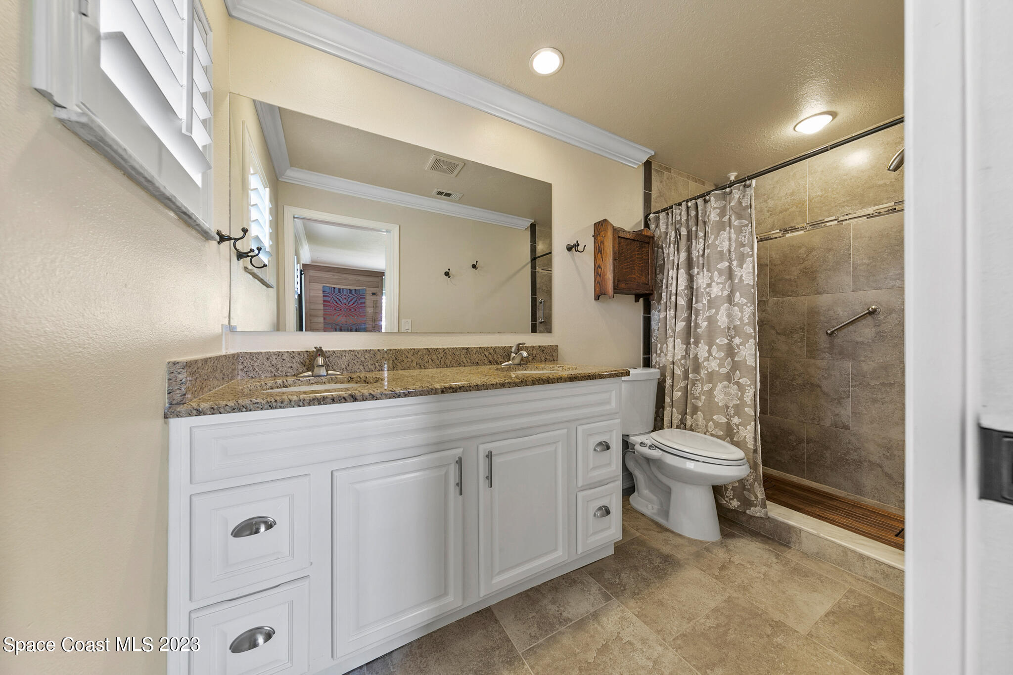 2900 Pine Branch Drive Melbourne, FL 32940 - Photo 26 of 48 a bathroom with a granite countertop sink toilet and shower