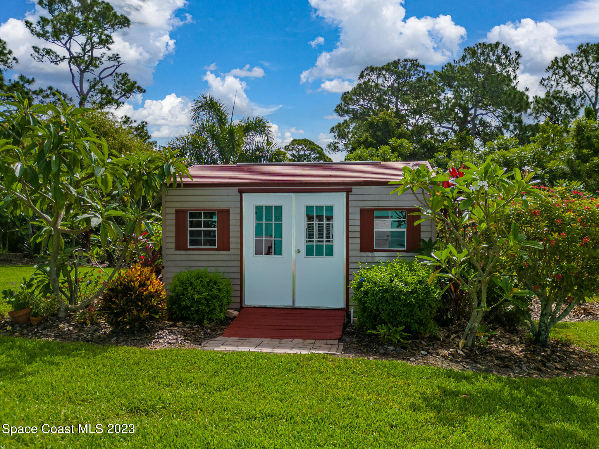2900 Pine Branch Drive Melbourne, FL 32940 - Photo 36 of 48 a front view of a house with a garden and yard