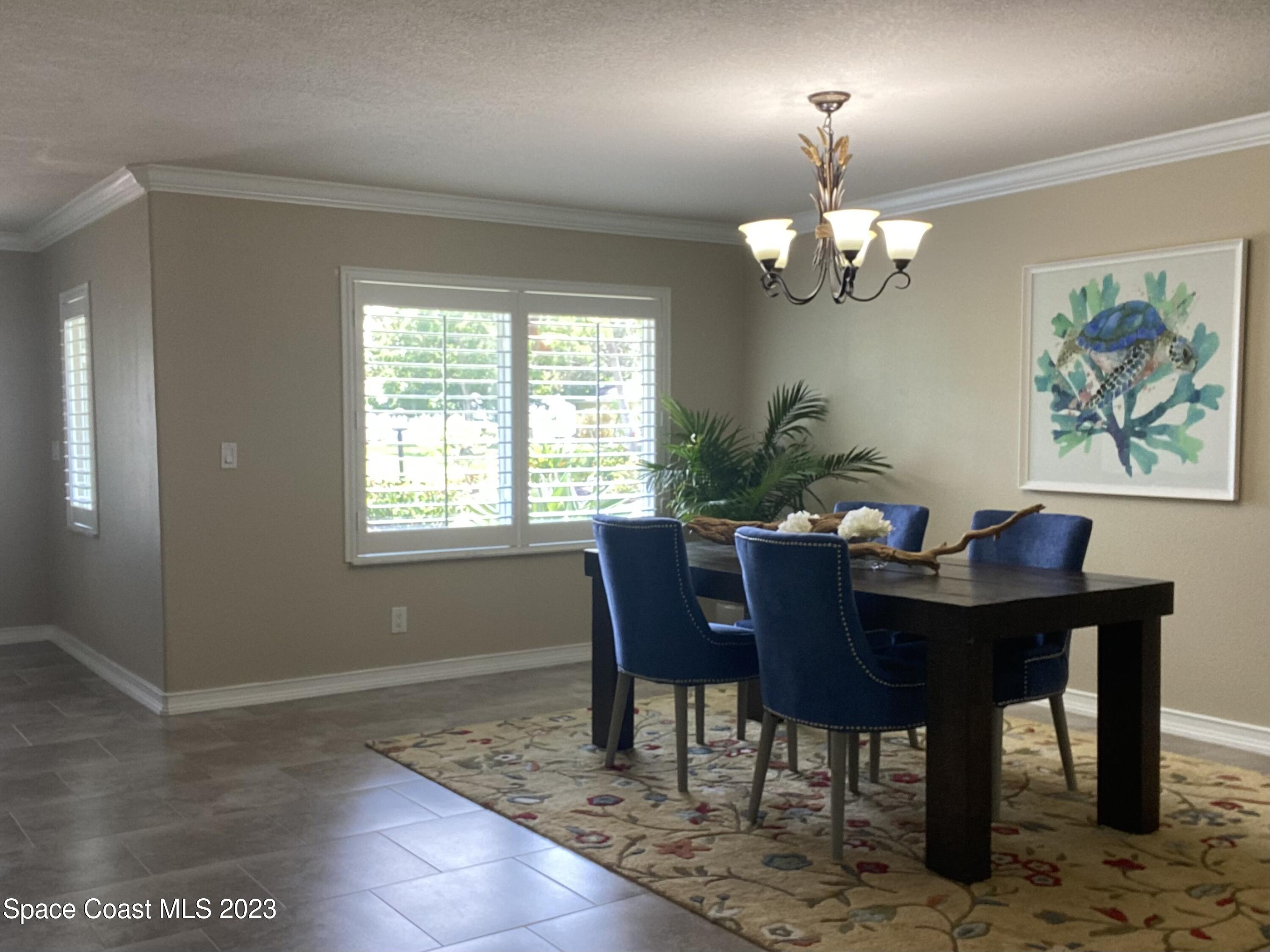2900 Pine Branch Drive Melbourne, FL 32940 - Photo 7 of 48 a view of a dining room with furniture a chandelier and wooden floor