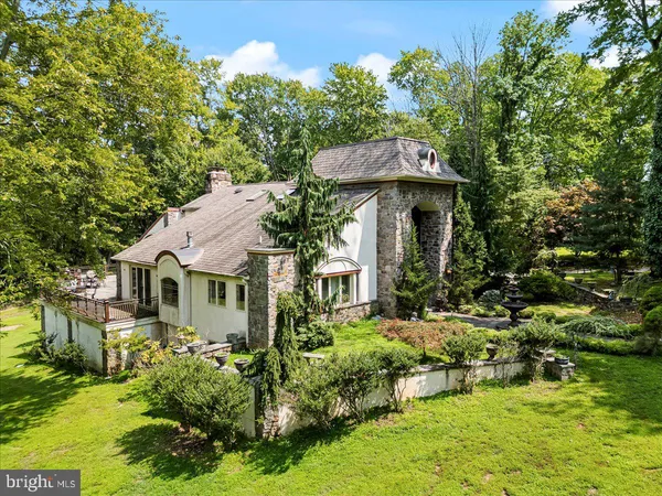 a view of a small house with potted plants and large trees