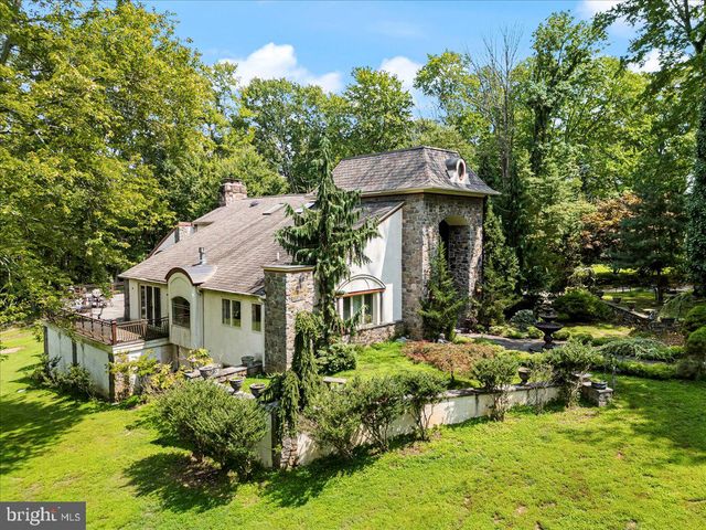 a view of a small house with potted plants and large trees