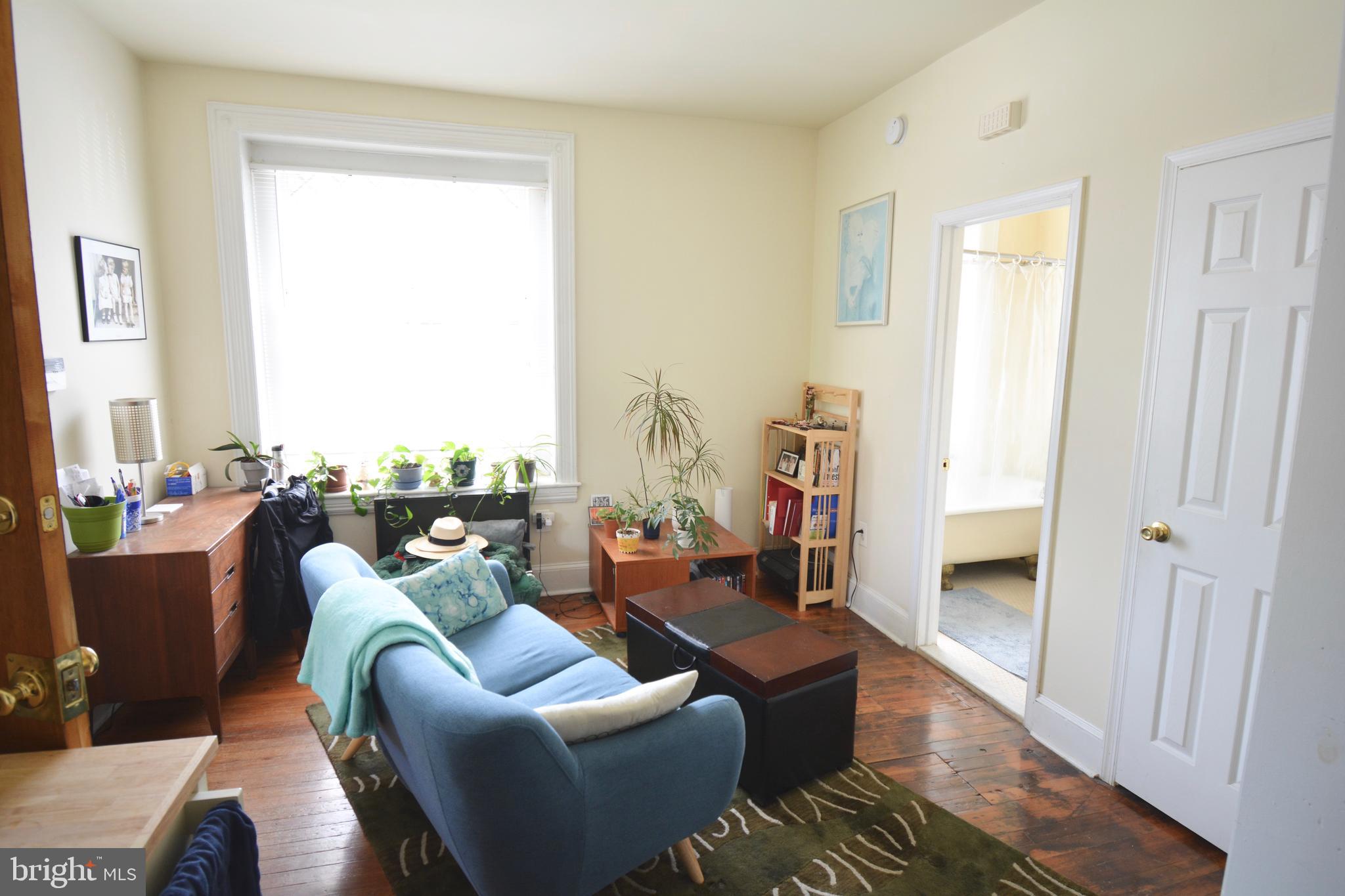 253 Hansberry Street, Unit 1F Philadelphia, PA 19144 - Photo 6 of 20 a living room with furniture and a large window