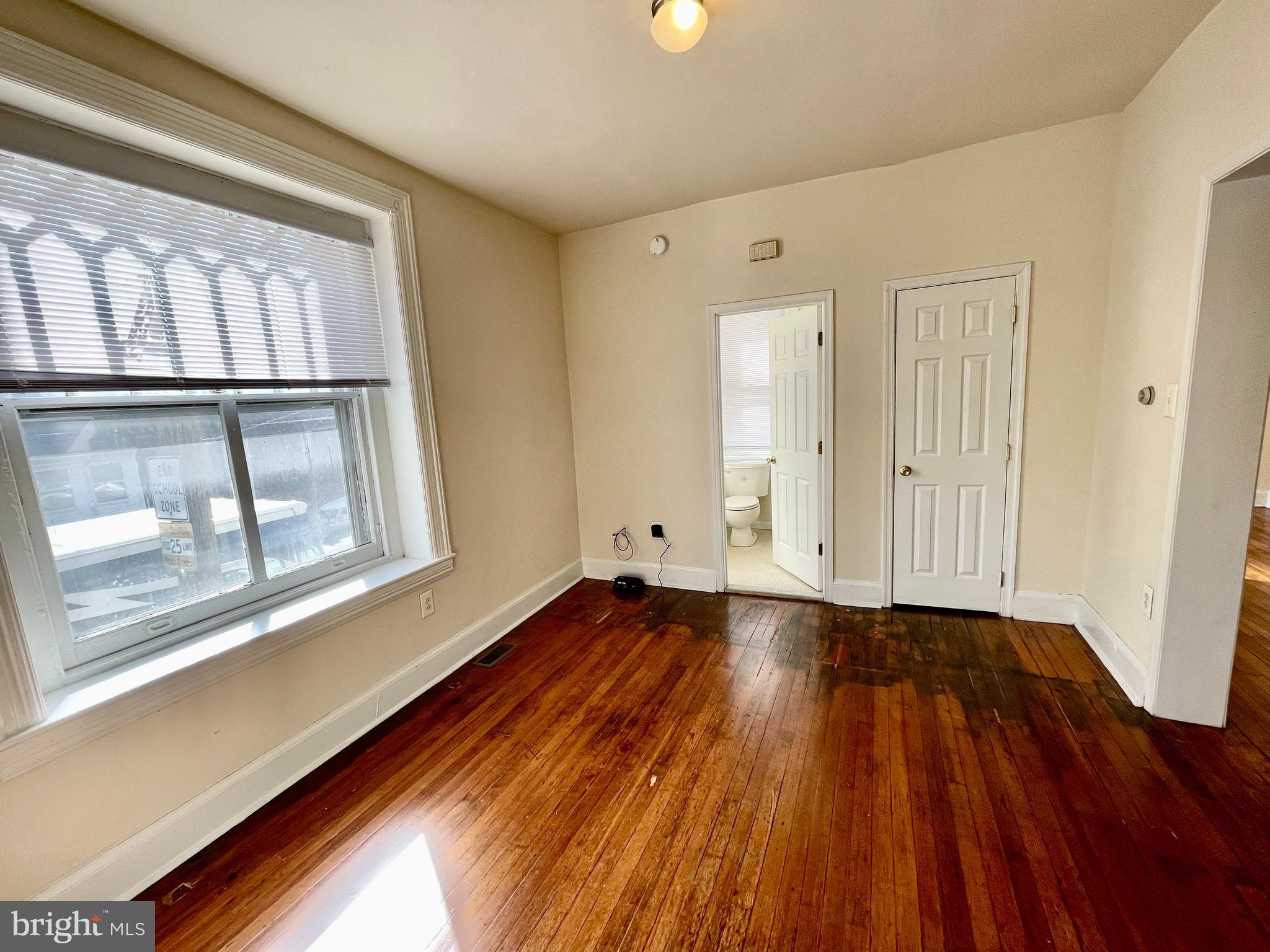 253 Hansberry Street, Unit 1F Philadelphia, PA 19144 - Photo 7 of 20 a view of an empty room with wooden floor and a window