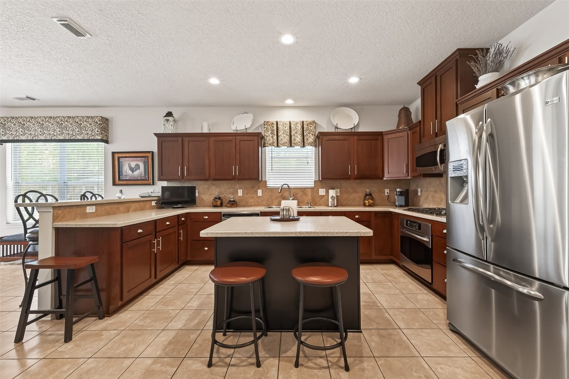 522 Beauregard Drive Conroe, TX 77302 - Photo 2 of 50 a kitchen with stainless steel appliances granite countertop a sink and a refrigerator