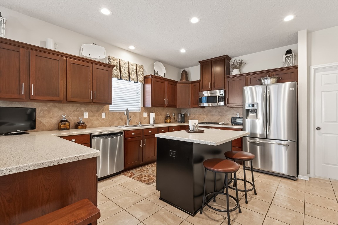 522 Beauregard Drive Conroe, TX 77302 - Photo 21 of 50 a kitchen with a sink a refrigerator and cabinets