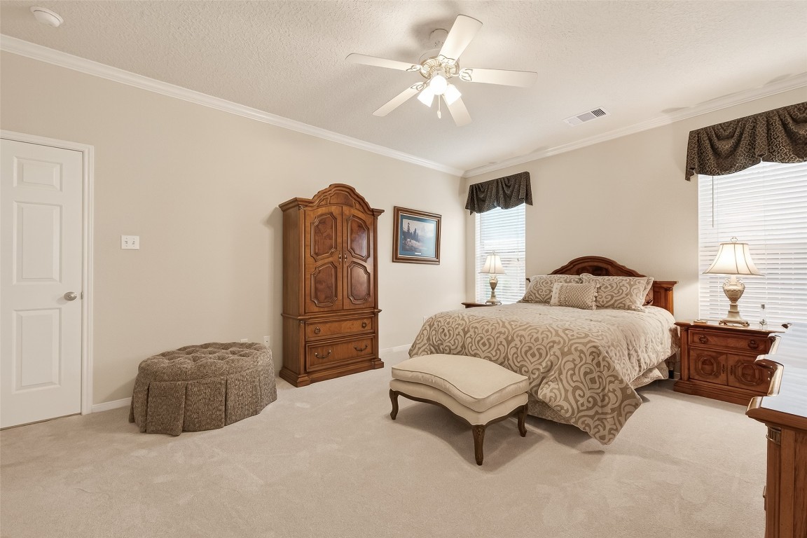 522 Beauregard Drive Conroe, TX 77302 - Photo 23 of 50 a spacious bedroom with a bed and a chandelier