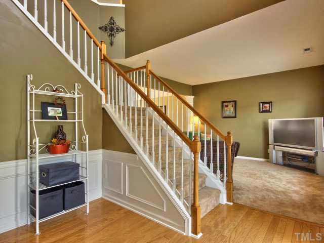 317 Grassy Point Road Apex, NC 27502 - Photo 2 of 25 Dramatic 2 story foyer features hardwood floor and wainscot.