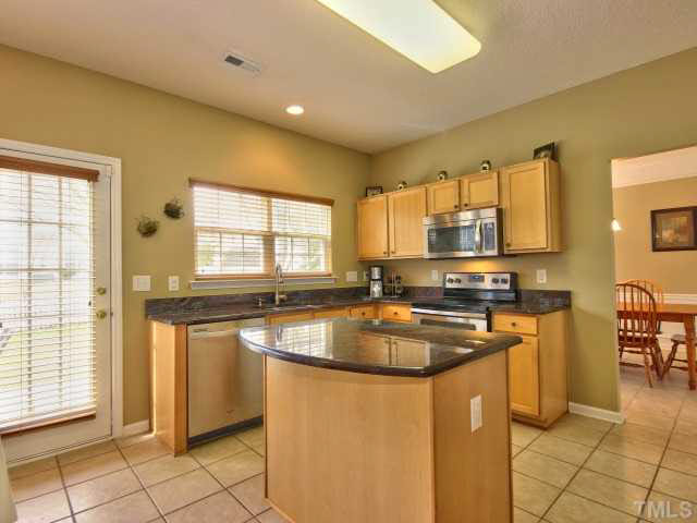 317 Grassy Point Road Apex, NC 27502 - Photo 3 of 25 Spacious kitchen with GRANITE countertops, island, pantry, maple cabinets and tile floors!