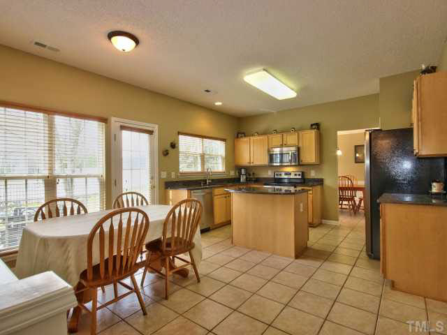 317 Grassy Point Road Apex, NC 27502 - Photo 4 of 25 Kitchen and breakfast room are full of natural sunlight.