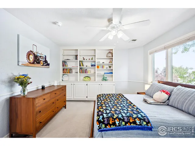 a bedroom with a bed cabinets and window