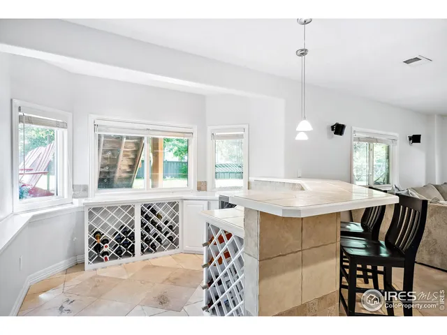 a kitchen with stainless steel appliances granite countertop a sink a stove a dining table and chairs