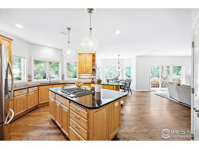 a kitchen with stainless steel appliances granite countertop a sink a stove a counter space and a window