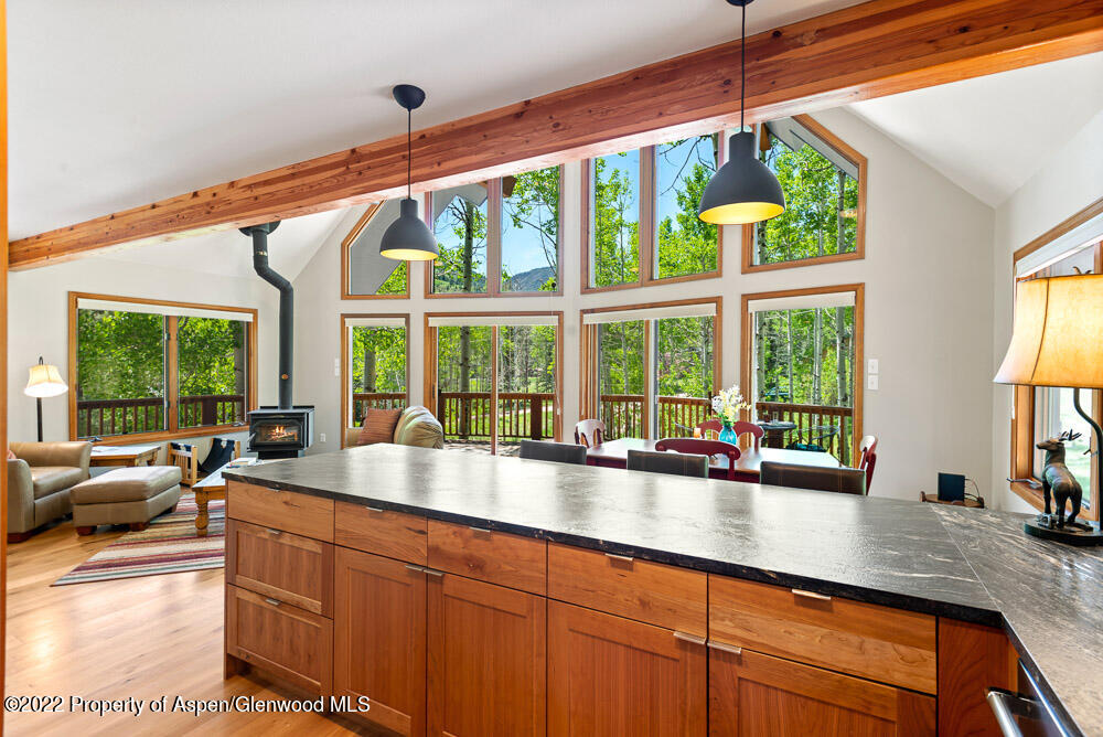 a open kitchen with granite countertop a large window and a white umbrella