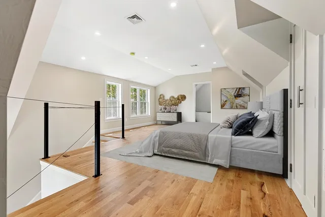 a living room with a bed furniture and a wooden floor