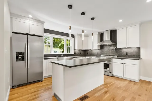 a kitchen with stainless steel appliances granite countertop a refrigerator a sink and a stove