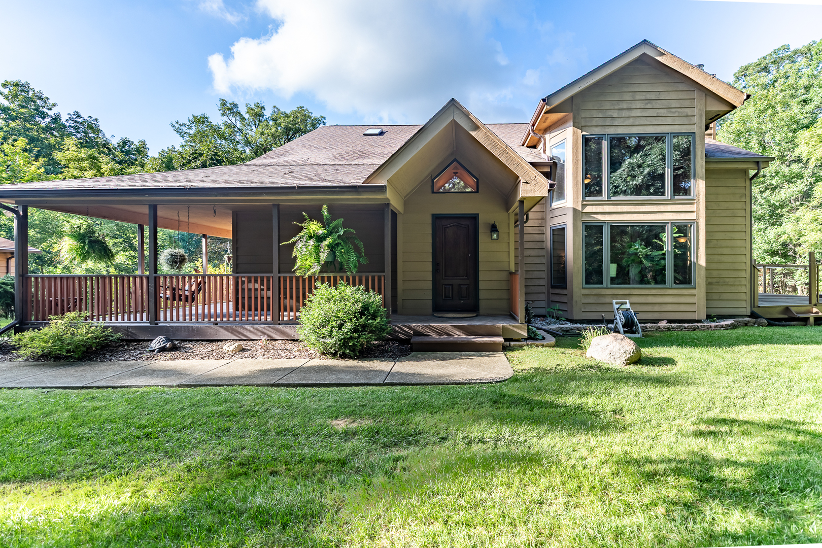 a front view of a house with yard and green space