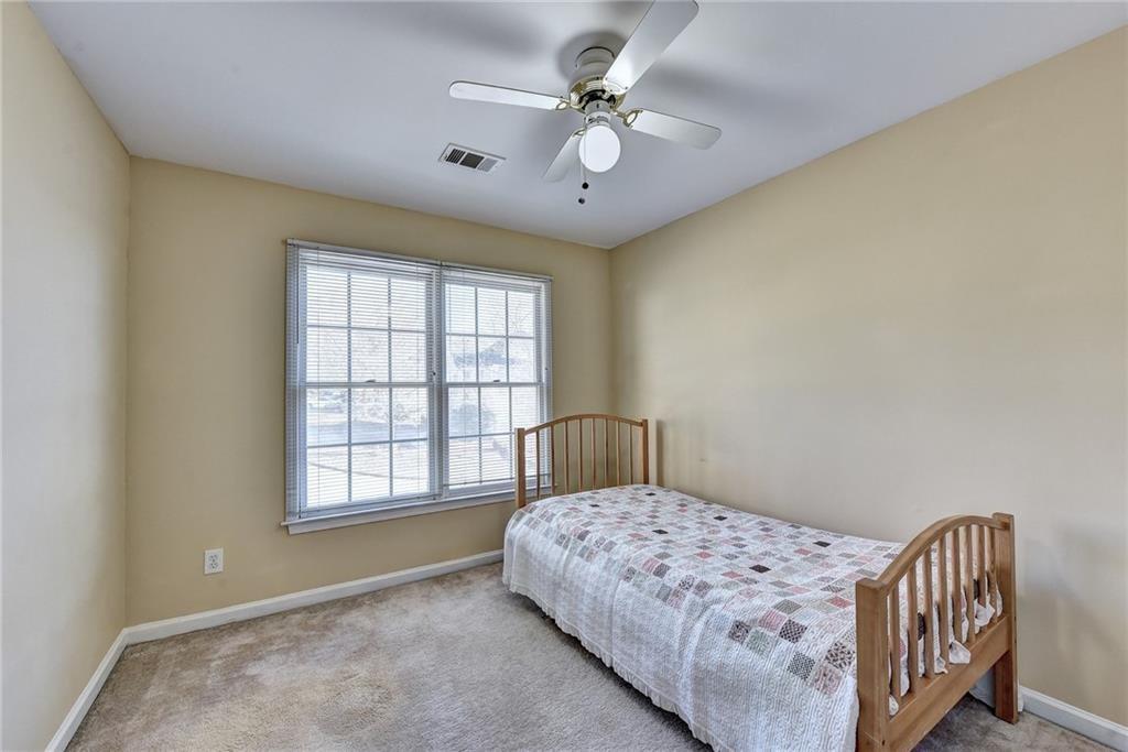 2390 Walnut Grove Way Suwanee, GA 30024 - Photo 15 of 22 a bedroom with a bed next to a window and a chandelier