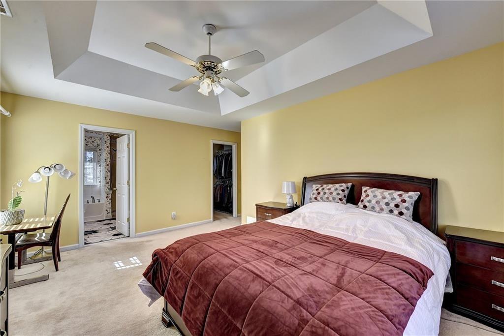 2390 Walnut Grove Way Suwanee, GA 30024 - Photo 19 of 22 a bedroom with a bed and a chandelier