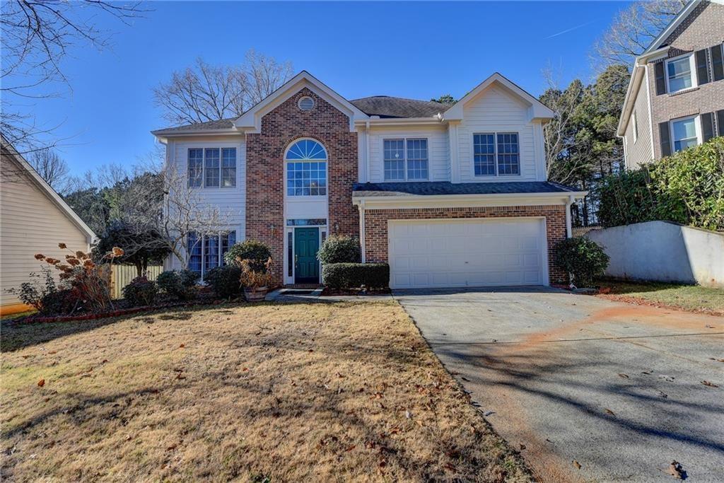 2390 Walnut Grove Way Suwanee, GA 30024 - Photo 4 of 22 a front view of a house with a yard and garage