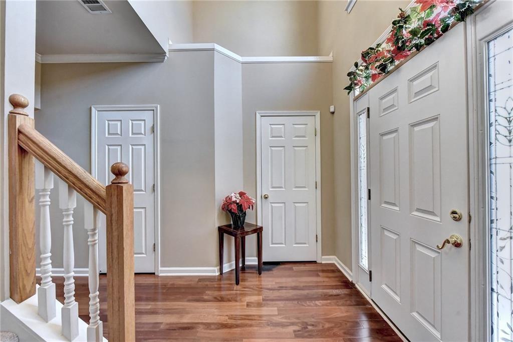 2390 Walnut Grove Way Suwanee, GA 30024 - Photo 5 of 22 a view of a hallway to a livingroom with wooden floor and stairs