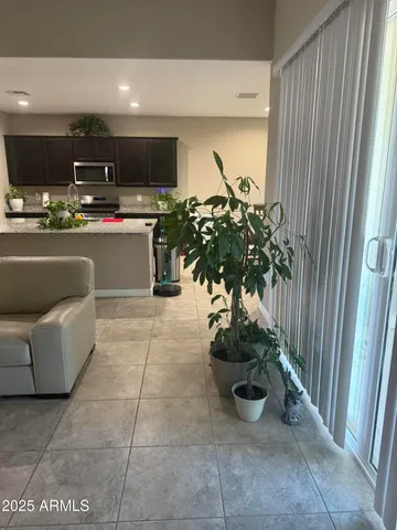 a living room with stainless steel appliances a counter top space cabinets and a potted plant