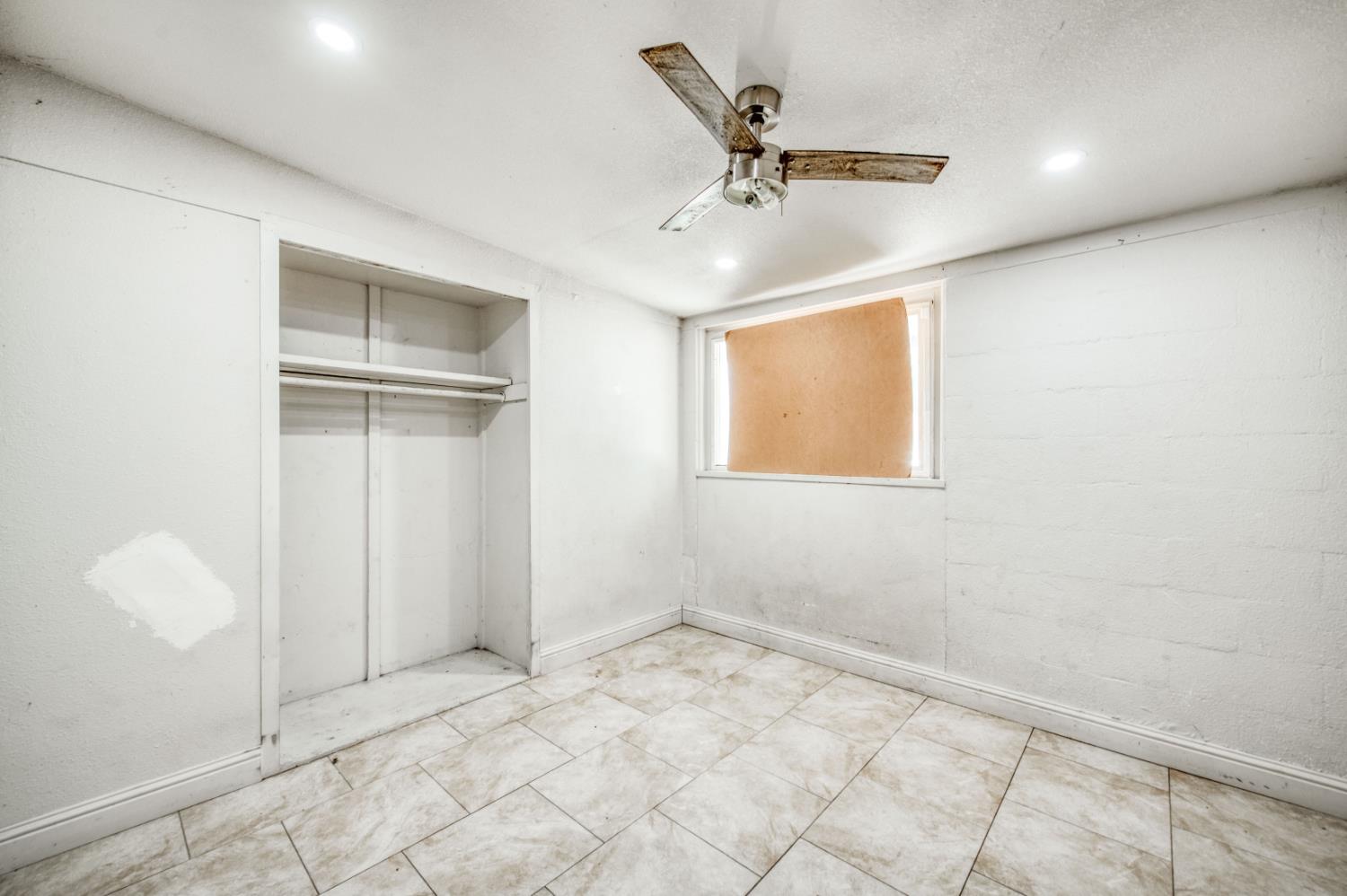 2326 East Hampton Way Fresno, CA 93726 - Photo 11 of 22 an empty room with windows and fan