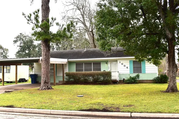 a front view of house with yard and trees around