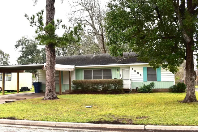 a front view of house with yard and trees around