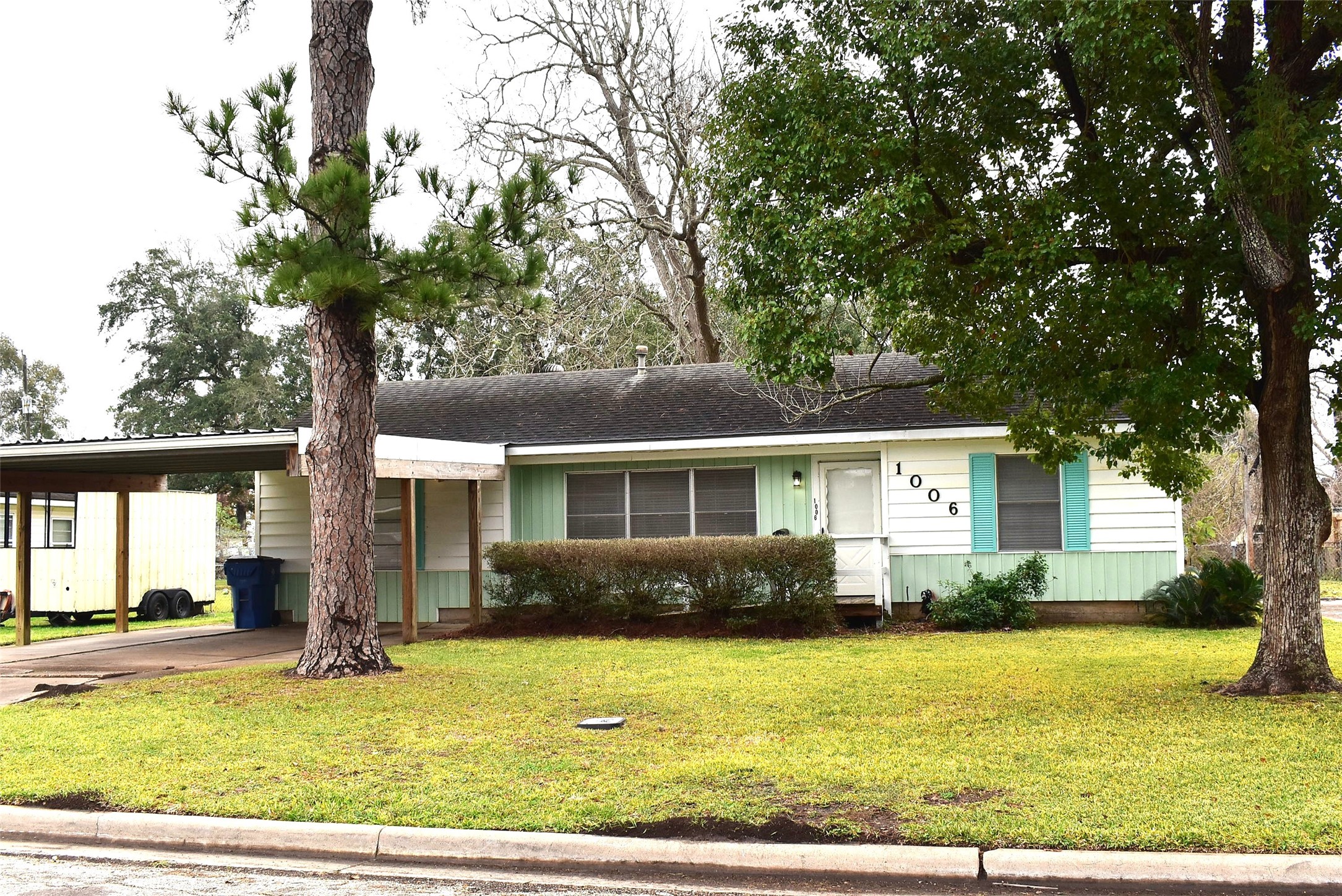 a front view of house with yard and trees around