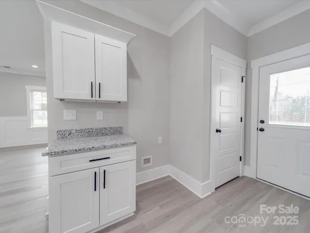 a kitchen with granite countertop white cabinets and a sink