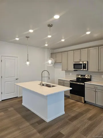 a large kitchen with granite countertop a stove top oven a sink a counter space and cabinets