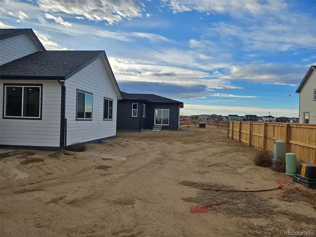 a view of a house with backyard and bushes
