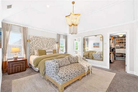 a bedroom with a large bed and a chandelier