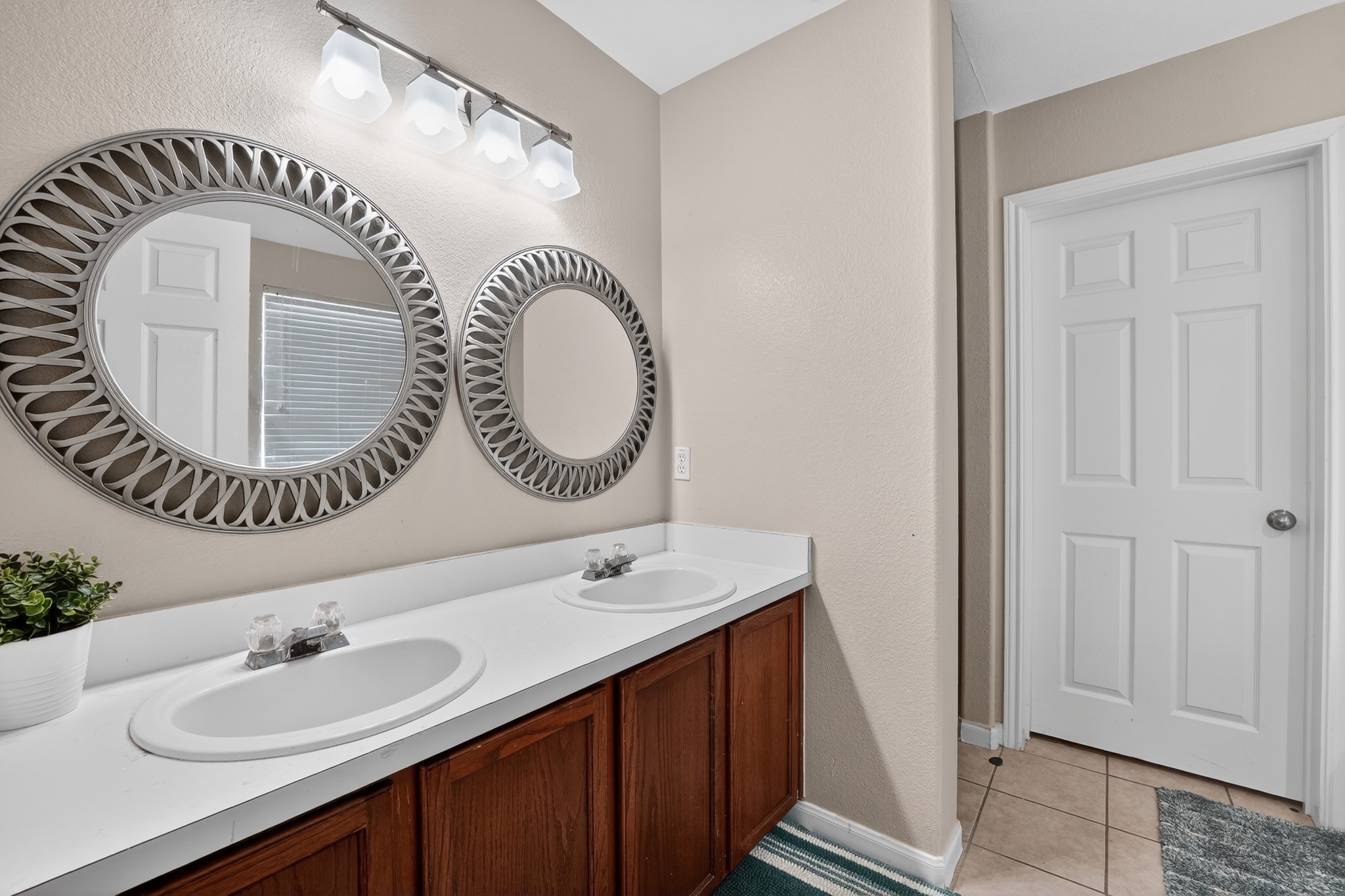 816 Rusk Road Round Rock, TX 78665 - Photo 24 of 29 Bathroom featuring a dual vanity with white countertops, integrated sinks, and wood-finish cabinetry