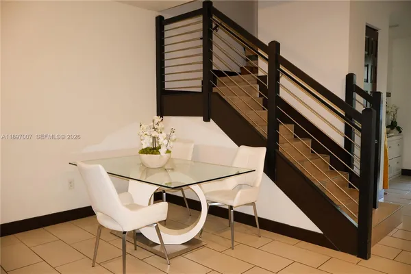 a kitchen with stainless steel appliances granite countertop a stove a refrigerator a sink a dining table and chairs