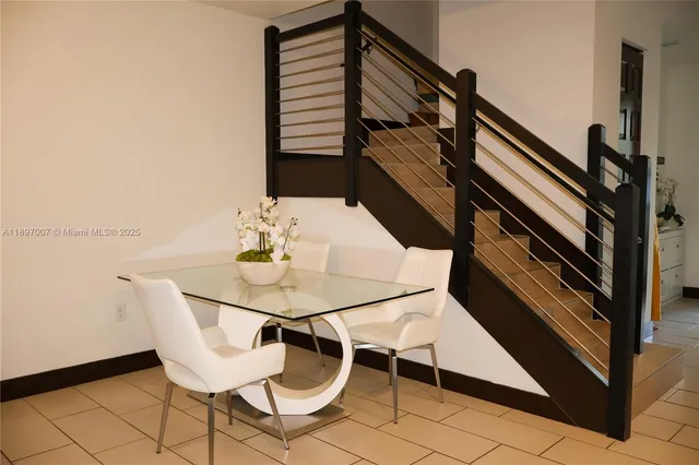 a kitchen with stainless steel appliances granite countertop a stove a refrigerator a sink a dining table and chairs