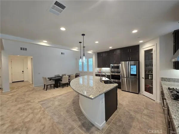 a kitchen with stainless steel appliances granite countertop a sink and a refrigerator