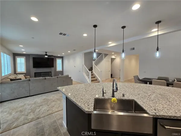 a kitchen with stainless steel appliances granite countertop a sink a counter and chairs