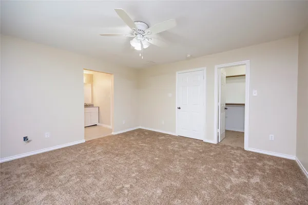 a view of an empty room with a chandelier fan